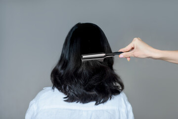 Fototapeta premium close-up hand combing hair with a comb. hairdresser services