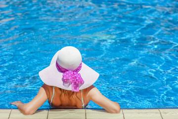 happy girl in a hat by the pool on the nature of the sea shore