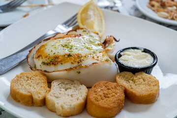 Grilled cuttlefish with garlic and parsley sauce, accompanied with toasted bread