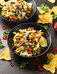 Mexican style salad of black beans, lentils, corn, tomato and lettuce with a salsa and tortilla chips