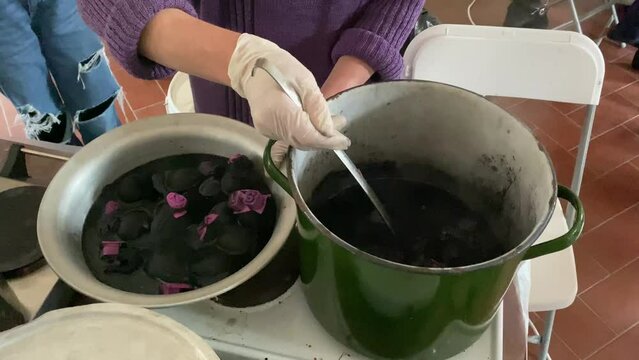 Easter eggs are dyed with black alder bark in a large pot