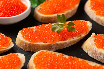 Salmon red caviar sandwiches on rustic stone board - obrazy, fototapety, plakaty