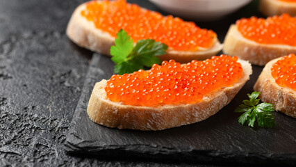 Naklejka na ściany i meble Salmon red caviar sandwiches on rustic stone board