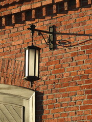delicate lantern on the brick wall of an ancient building