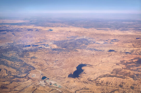 aerial view of arid climate and reservoirs in a dry summer in california alameda county-pleasenton livermore- los vaqueros resevoir and central valley  in the background