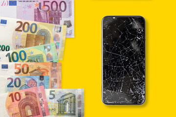 Black broken touch screen phone and euros banknotes