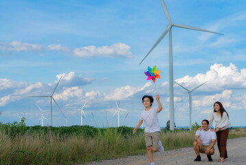 Progressive happy family enjoying their time at wind farm for green energy production concept. Wind...