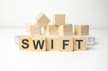 wooden cube block with swift business word on table background.