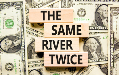 The same river twice symbol. Concept words The same river twice on wooden block. Beautiful background from dollar bills. Motivational business the same river twice concept. Copy space.