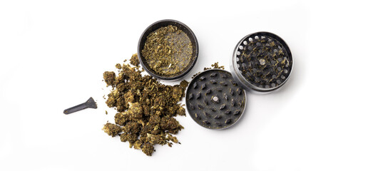 Obraz na płótnie Canvas Dried cannabis buds in a grinder on a white background with copy space. Mill with marijuana on a white table, top view. Drug use concept