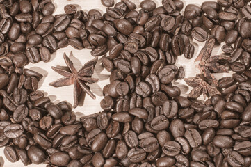nasiona kawy i anyżu na jasnym drewnianym tle