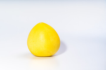 żółty owoc pomelo (Rutaceae) na jednolitym jasnym lub białym tle - obrazy, fototapety, plakaty