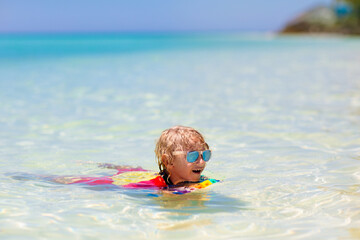 Kids surf on tropical beach. Vacation with child.