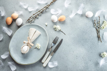 Easter table setting with bunny ears made of egg and napkin on light grey background. Happy Easter holiday concept. place for text, top view