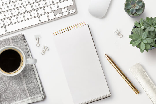planning the day, writing a to do list /checklist, top view of a feminine workspace / desk with an open ringbinder a ballpoint pen, computer tools, potted succulents and black coffee, business concept