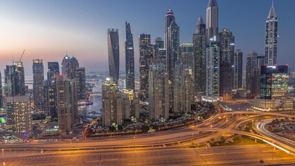 Skyscrapers of Dubai Marina near intersection on Sheikh Zayed Road with highest residential buildings day to night timelapse