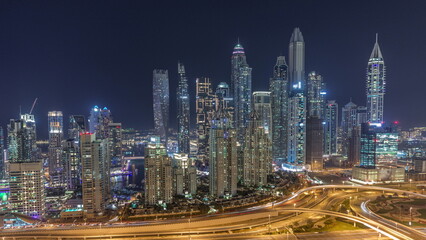 Obraz na płótnie Canvas Skyscrapers of Dubai Marina near intersection on Sheikh Zayed Road with highest residential buildings night timelapse