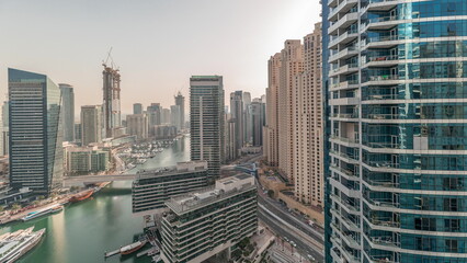 Fototapeta premium Panorama showing overview to JBR and Dubai Marina skyline with modern high rise skyscrapers waterfront living apartments aerial timelapse