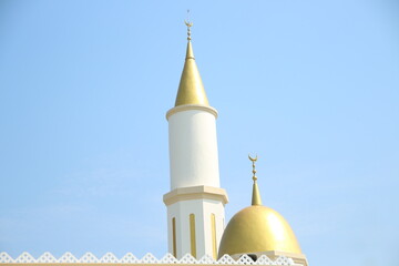 Gold dome and Minaret of the masjid sign of Islam blue sky background