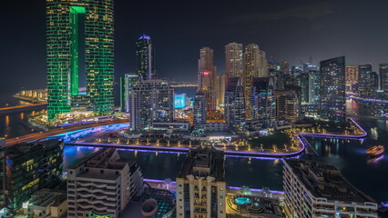 Fototapeta premium Panorama showing Dubai Marina skyscrapers and JBR district with luxury buildings and resorts aerial night timelapse