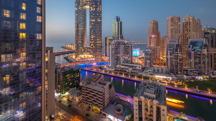 Naklejka premium Dubai Marina skyscrapers and JBR district with luxury buildings and resorts aerial day to night timelapse
