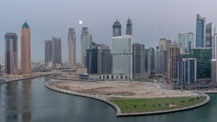 Obraz premium Cityscape of skyscrapers in Dubai Business Bay with water canal aerial night to day timelapse