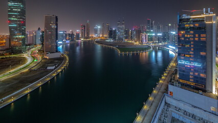 Cityscape of skyscrapers in Dubai Business Bay with water canal aerial all night timelapse