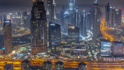 Aerial view of tallest towers in Dubai Downtown skyline and highway all night timelapse.