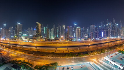 Fototapeta na wymiar Panorama of Dubai Marina skyscrapers and Sheikh Zayed road with metro railway aerial all night timelapse, United Arab Emirates