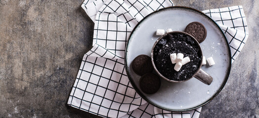 Quick chocolate cake mug with marshmallows on a plate on the table top view web banner