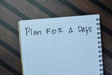 Concept of Plan For a Days write on book isolated on Wooden Table.