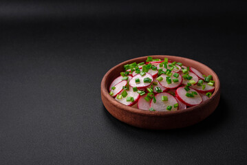 Delicious fresh salad of sliced ??radishes with green onions, salt and olive oil