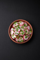 Obraz na płótnie Canvas Delicious fresh salad of sliced ??radishes with green onions, salt and olive oil