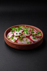 Delicious fresh salad of sliced ??radishes with green onions, salt and olive oil