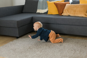 Nursery baby boy crawling on floor indoors at home copy space and empty space for text - Baby...