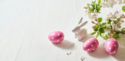 Holiday composition with spring flowers and easter eggs, white bunny on a light background. Happy easter concept with copy space