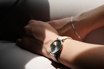 Frauenhände mit Armbanduhr und Silberkette