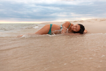 Beautiful Asian woman peacefully laying on the beach