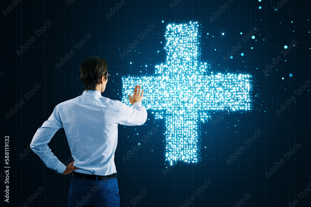 Poster back view of businessman pointing and using creative glowing medical cross plus hologram on dark bac