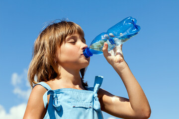 Attractive young beautiful girl drinking water from plastic bottles - 588119339