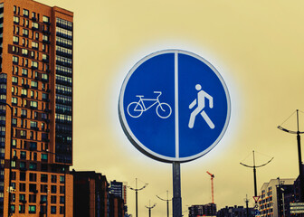 natural light. road sign on the background of buildings. pedestrian cyclist. residential area.