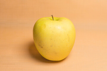 yellow apple on orange background