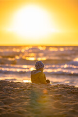 Dziecko oglądające zachód słońca nad Bałtykiem / A child watching the sunset over the Baltic...