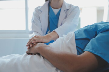 Women Asian doctors hold the patient hand and encourage and provide medical advice While checking...