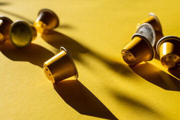 Coffee capsules under natural light on a yellow background