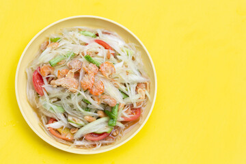 Dish of spicy papaya salad on white.