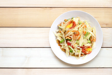 Dish of spicy papaya salad on white.