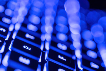 Macro closeup of electronic LED back lit keyboard, blue and white lighting 