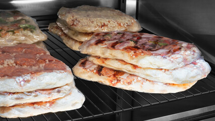 Pizza blanks in the refrigerator in a pizzeria