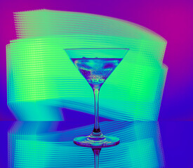 Alcoholic cocktail in a glass goblet against the background of bright neon lights